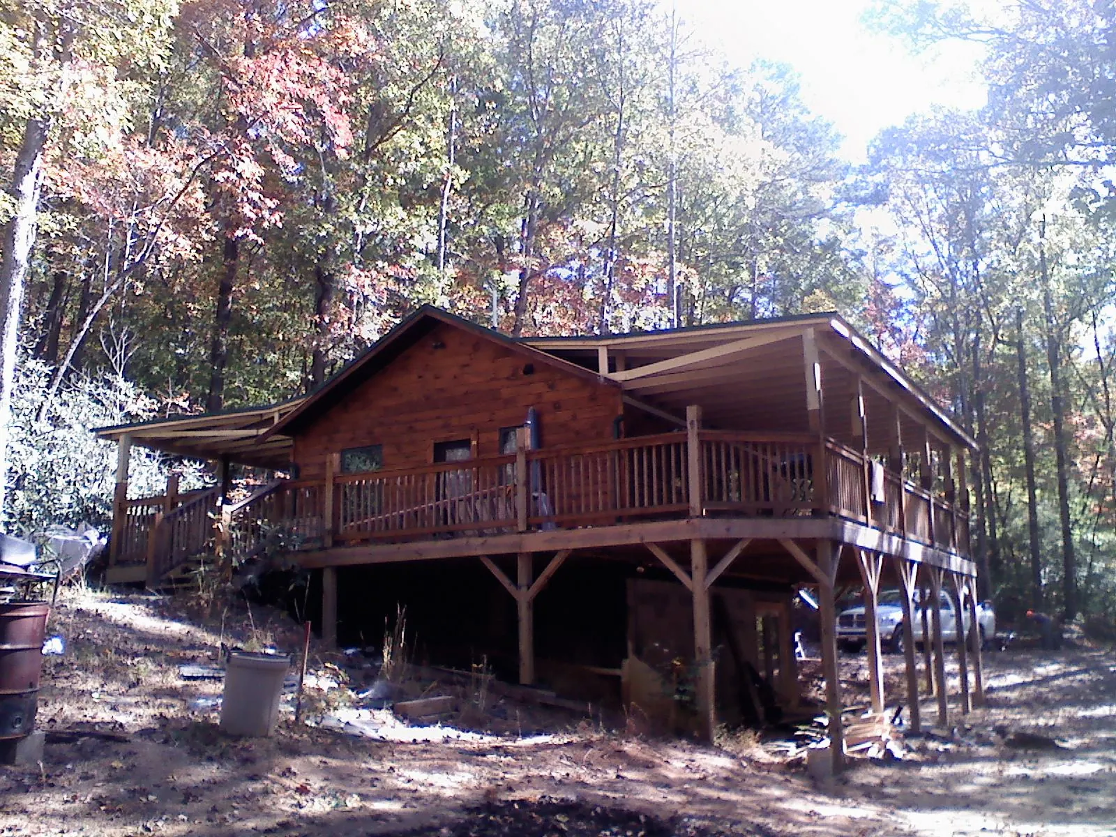 Log cabin with a wraparound porch and metal roof in the fall in Epworth